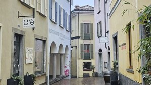 Una calle estrecha flanqueada por edificios, incluyendo un restaurante llamado "C'est le Pharmacie".