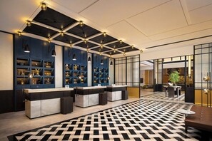 A modern lobby with a check-in counter, blue shelving with decorative items, and a patterned floor. - Four Points by Sheraton Chongqing Jiulongpo (Chongqing)