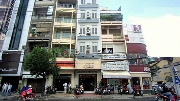 Un edificio de varios pisos con diferentes tiendas en la planta baja.