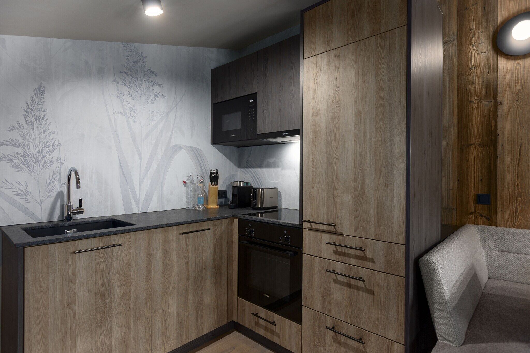 A modern kitchen with wooden cabinets, a built-in microwave, and a stainless steel sink.