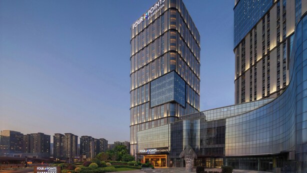 A modern hotel with a glass facade, multiple floors, and a prominent signage. - Four Points by Sheraton Tianshui (Tianshui)