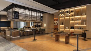 A modern bar area with a foosball table, bar stools, and a well-lit display of bottles and glasses. - Four Points by Sheraton Tianshui (Tianshui)