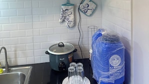 A kitchen with a stove, a sink, and a water dispenser. - Cozy 1-Bedroom House Rental in Hermosa, Philippines (Hermosa)