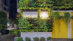 A building facade with a sign reading "33 VIEI LOTUS" and a yellow door. - Viet Lotus Saigon Hotel (Ho Chi Minh City)