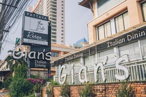Een gebouw met een bord waarop 'Pattaya The Dale' en 'Relax' spa en 'Gian's Italian Dining' staan.