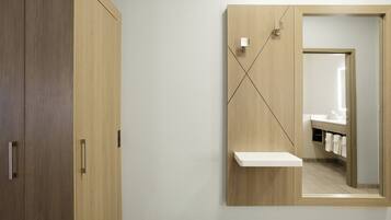 Un baño moderno con tocador de madera, un espejo y un perchero para toallas.
