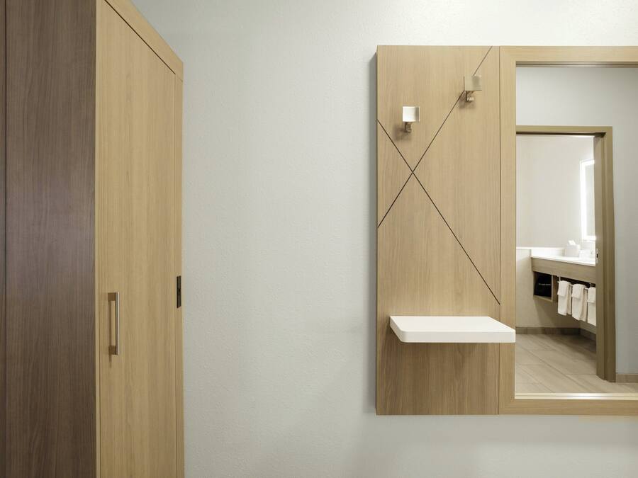 Un baño moderno con tocador de madera, un espejo y un perchero para toallas.