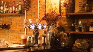 A bar area with a tap, bottles, and a sign that says 'Be Grateful, Give Love, Laugh Lots'. - Tony Lodge (Takua Pa)