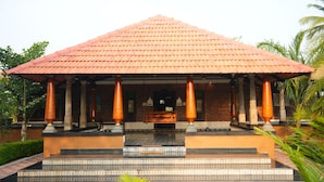 A building with a tiled roof, columns, and steps leading to a door. - PRABANCH GARDENS - A CONSCIOUS STAY (Chengalpattu)