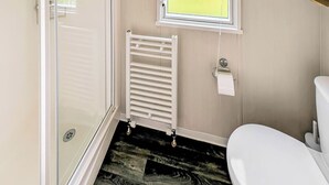 Ein Badezimmer mit Toilette, Heizkörper und Fenster.