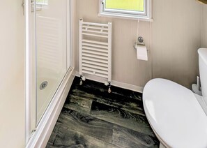 A bathroom with a white toilet, a radiator, and a window. - 2 bedroom accommodation in Haverigg, Millom (Haverigg, Millom)