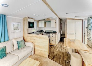 A compact RV interior with a kitchenette, a dining area, and a seating space. - 2 bedroom accommodation in Haverigg, Millom (Haverigg, Millom)