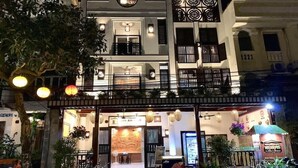 A multi-story building with a restaurant on the ground floor, featuring a traditional design with a balcony and decorative elements. - Vinh Hung Library Hotel (Hoi An)
