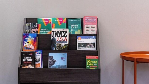 A bookshelf with various books and magazines. - K Pop Residence I (Seoul)