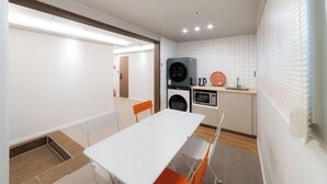 A compact kitchen with a washing machine, microwave, and sink. - K Pop Residence I (Seoul)