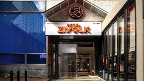 A building with a modern glass facade and a sign for 'ZIOYOLK' at the entrance. - K Pop Residence I (Seoul)