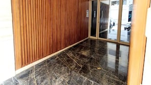Un pasillo con paneles de madera y suelo de mármol pulido.