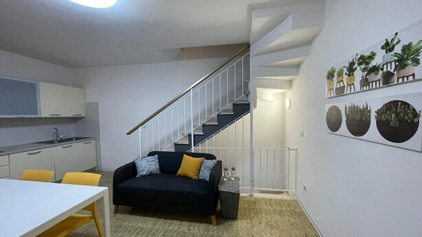 Un appartement moderne doté d’une cuisine, d’un coin repas et d’un escalier.