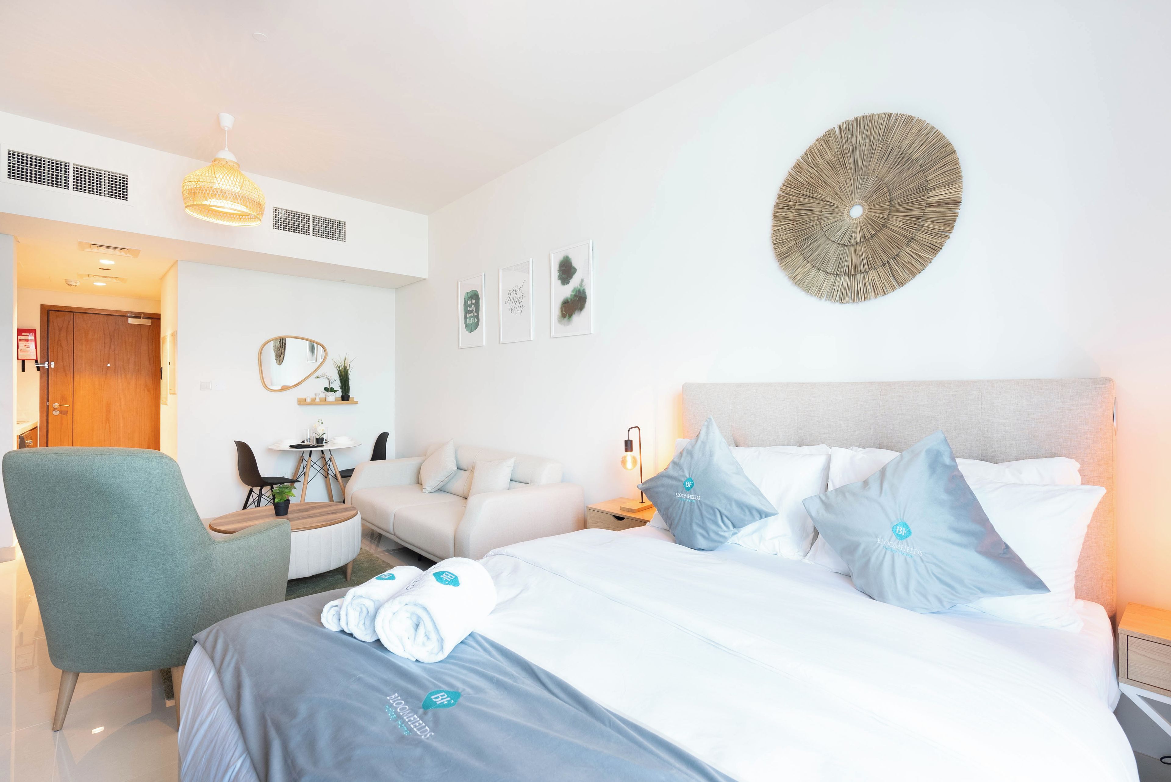 Una habitación de hotel moderna con una cama, un escritorio, una silla y un adorno circular en la pared.