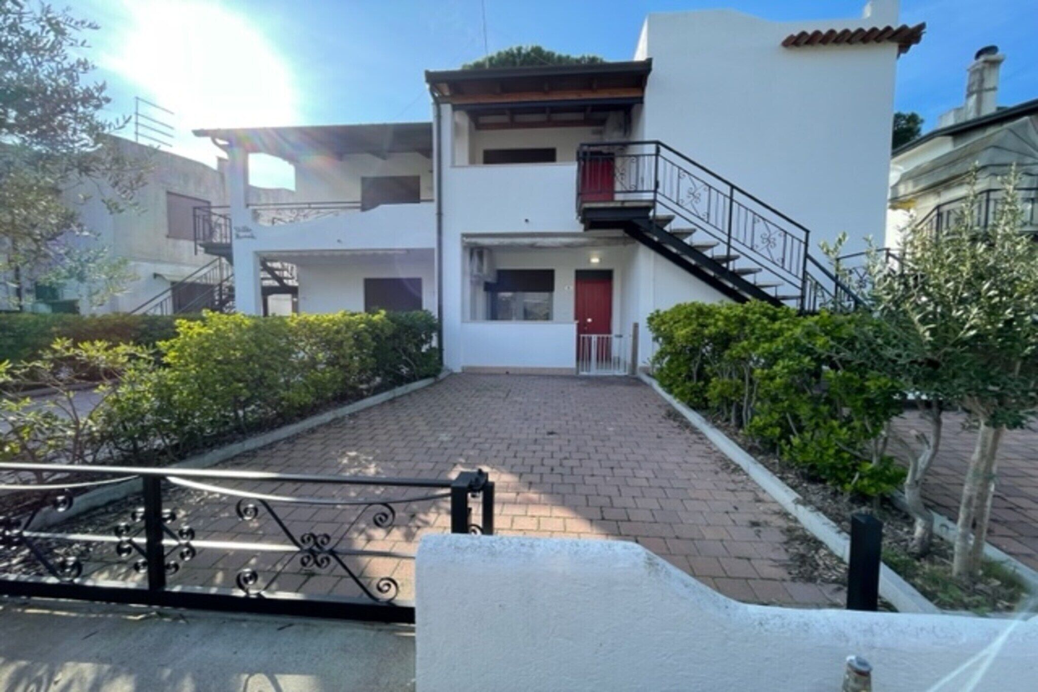 A two-story building with a red door and a balcony.
