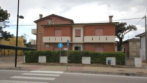 Un edificio de dos pisos con fachada de ladrillo, un paso de peatones y un cartel azul que indica zona peatonal.