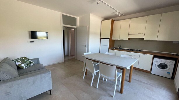 Un apartamento moderno con sala de estar, mesa de comedor y cocina.
