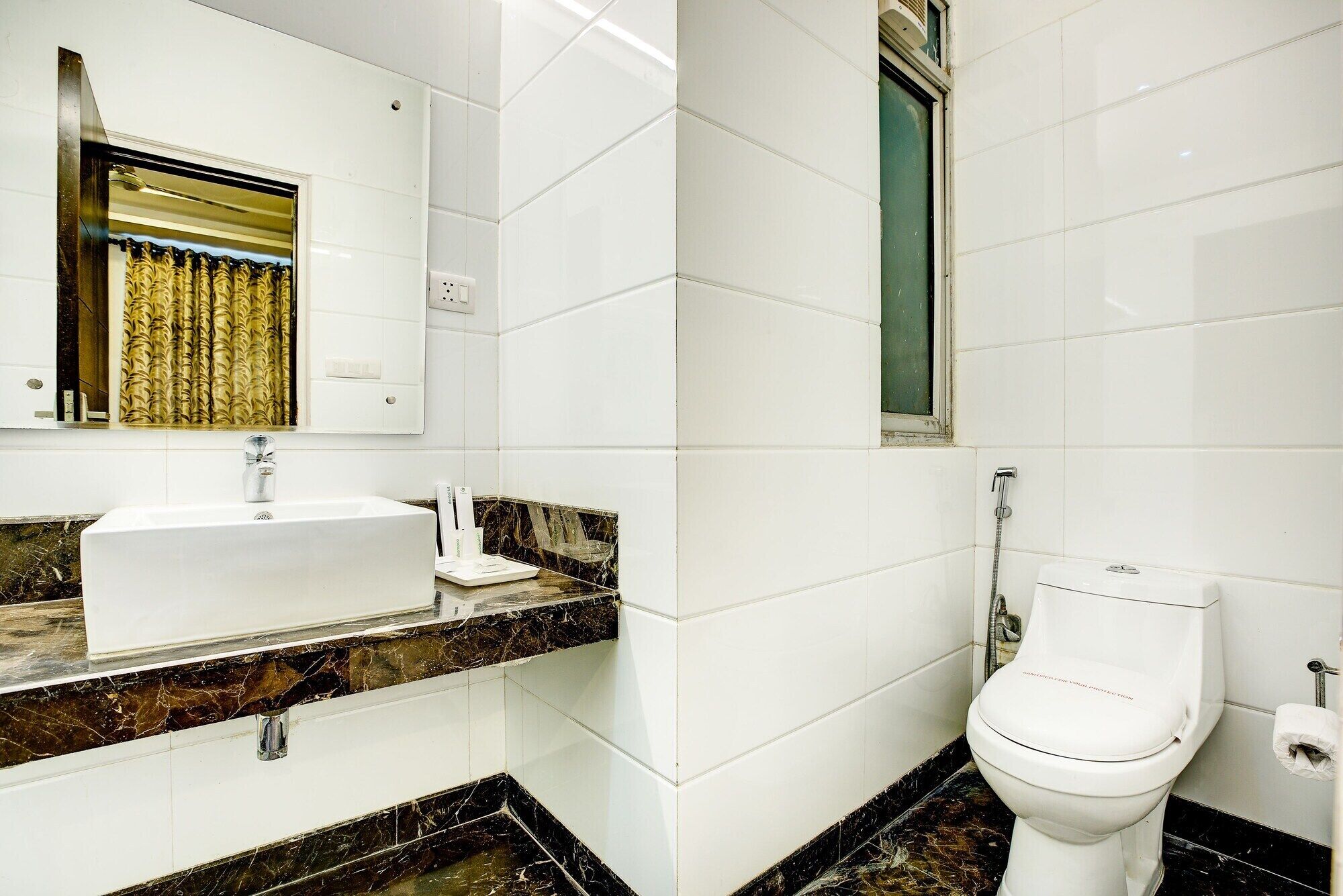 A bathroom with a white sink, a mirror, a toilet, and a shower.