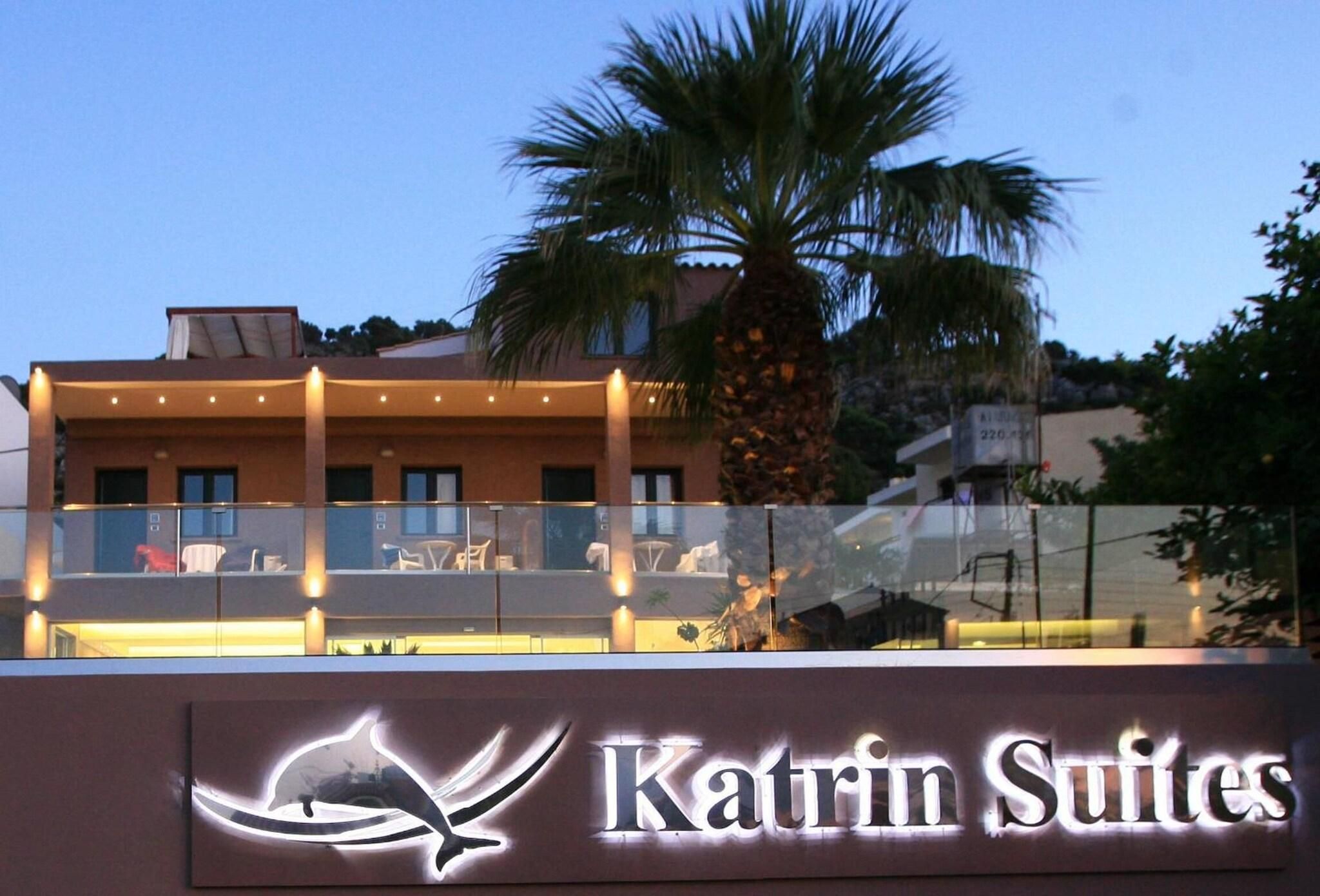 A hotel sign with a dolphin logo and the name 'Katrin Suites'.