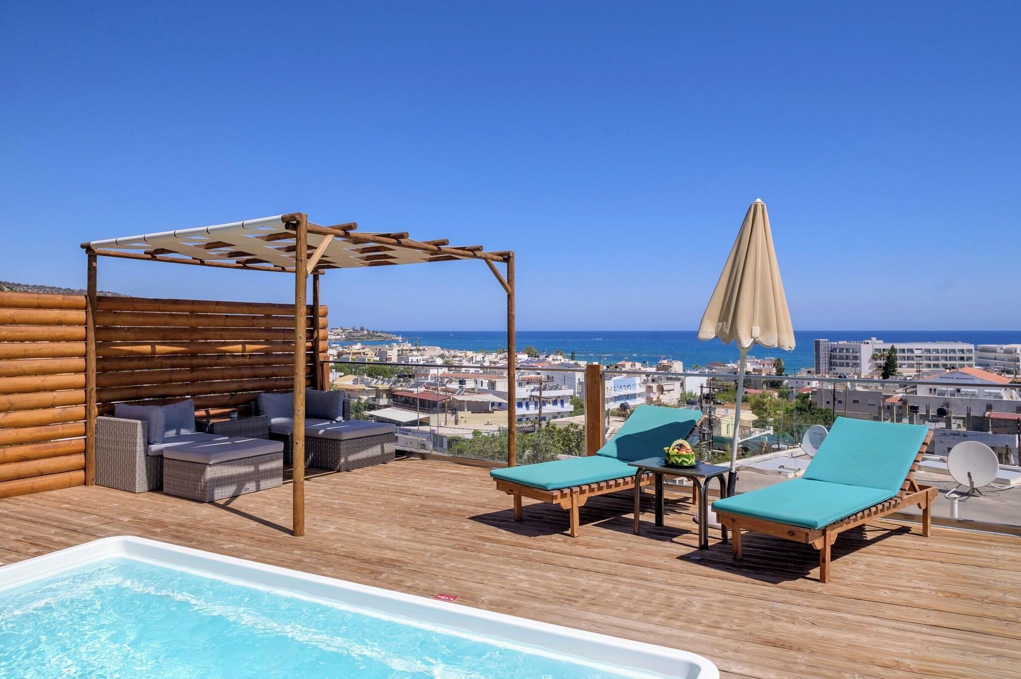 A rooftop terrace with a pool, lounge chairs, a pergola, and a view of the city and sea.