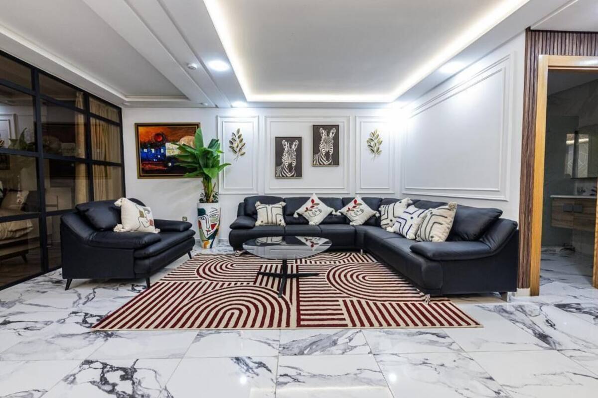 A modern living room with a sectional sofa, a coffee table, and a patterned rug.