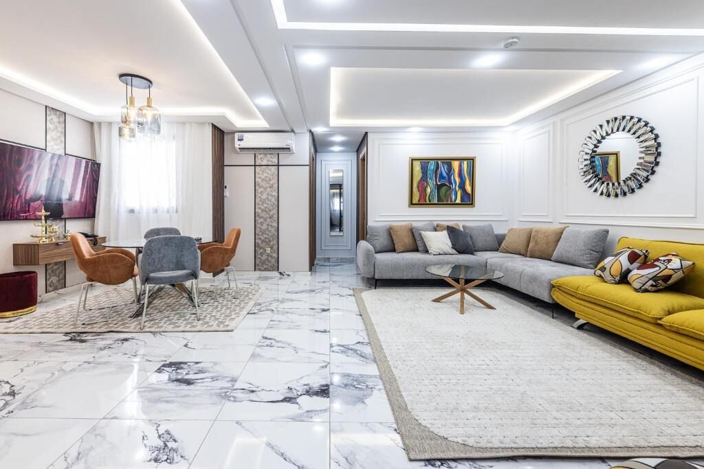 A modern living room with a marble floor, a sofa, a coffee table, and a TV.