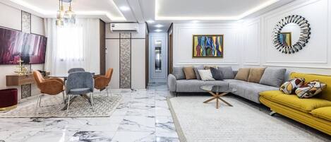 A modern living room with a marble floor, a sofa, a coffee table, and a TV.