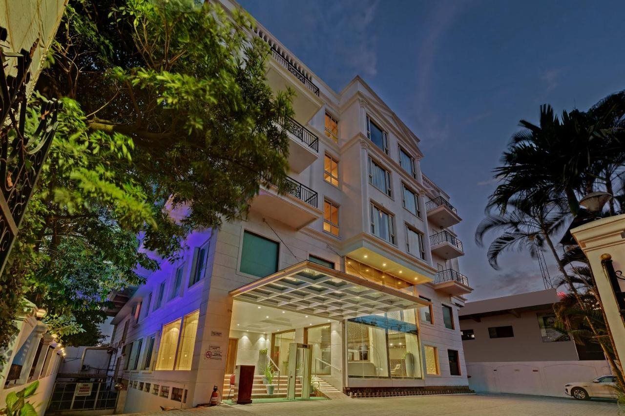 A multi-story hotel with a glass entrance, balconies, and a covered outdoor area.
