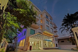 A multi-story hotel with a glass entrance, balconies, and a covered outdoor area. - The Fern Residency Hubballi (HUBBALLI)