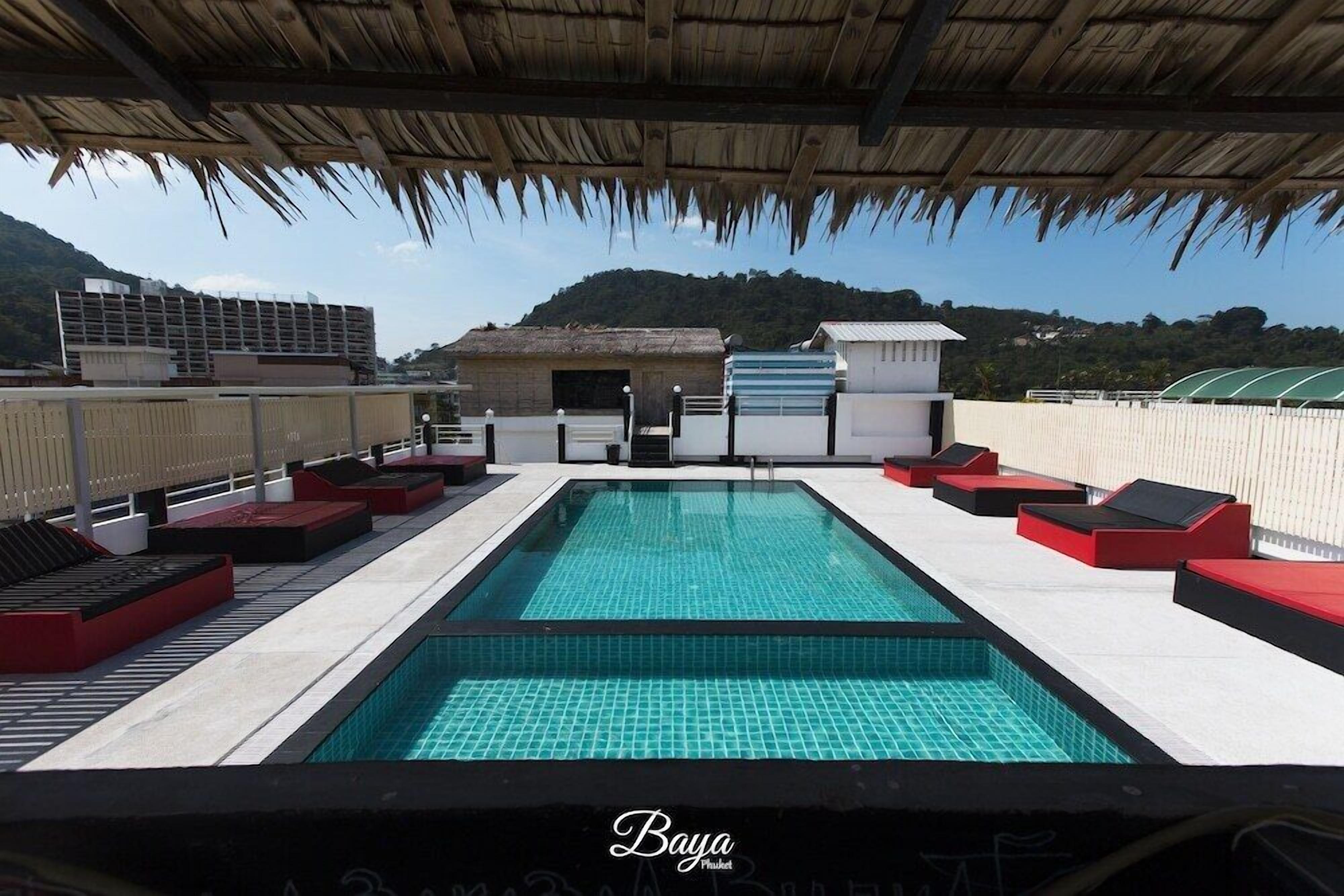 A rooftop pool with a clear view of the surrounding landscape, including mountains and a building in the background.