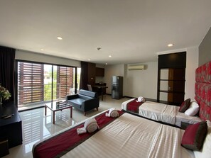 A hotel room with two beds, a sofa, a dining table, and a kitchen area. - Le Vernissage Hotel (Pattaya)