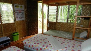 A room with two beds, a calendar, and a view of greenery outside. - Panglao Chocolate Hills Resort (Panglao)
