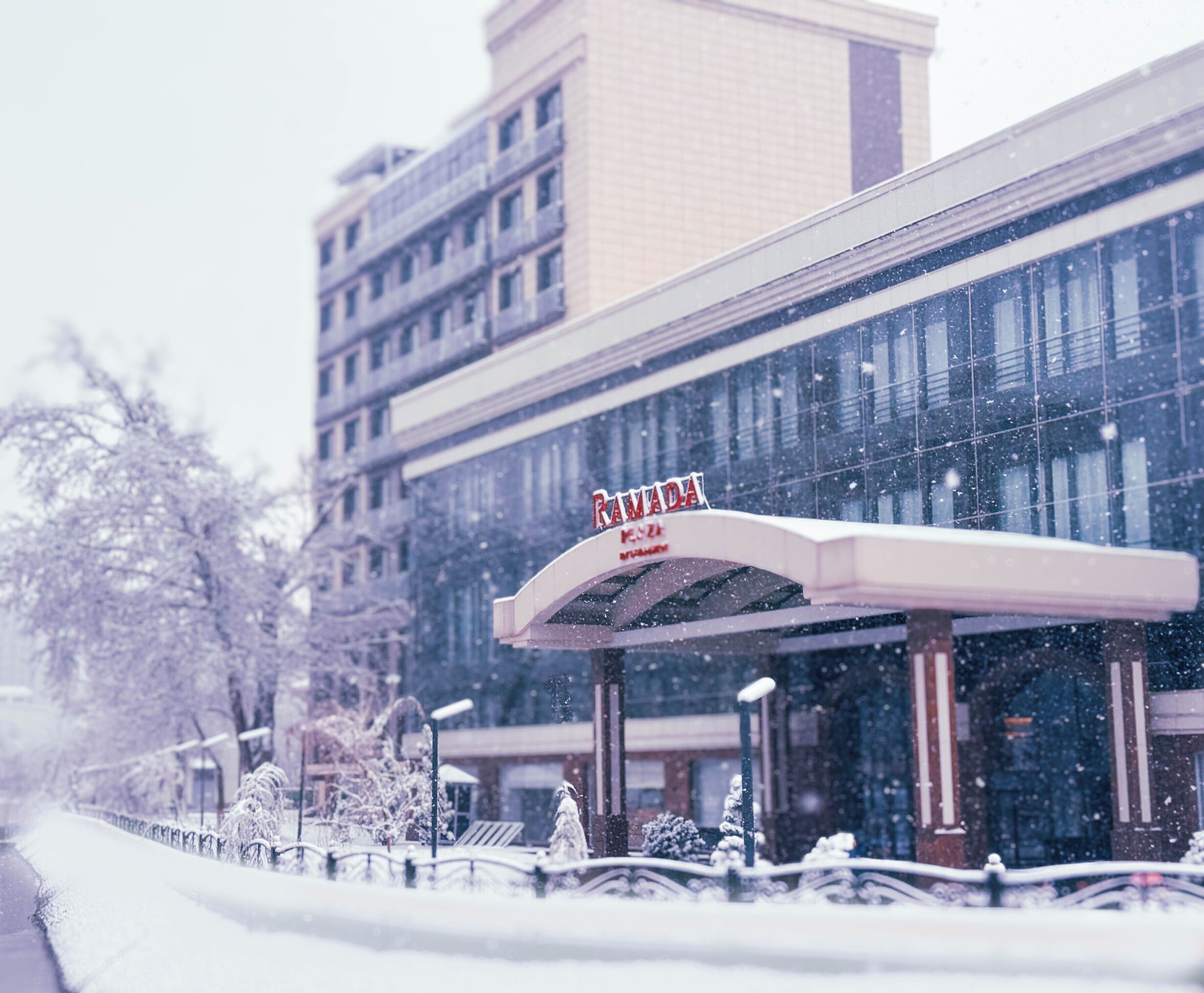A hotel with a sign reading "RAMADA" and a snow-covered exterior.