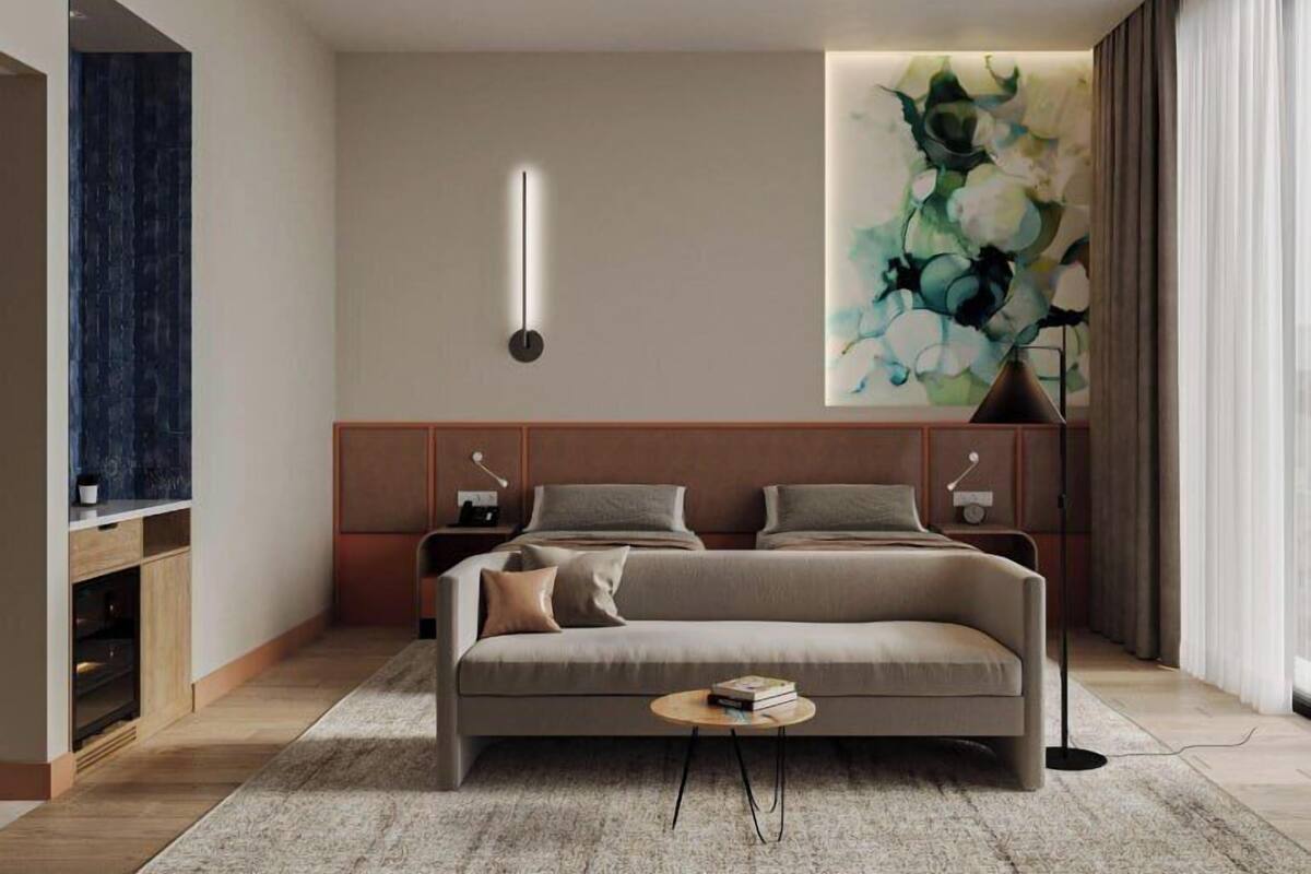 A modern bedroom with a sofa bed, a side table, a wall-mounted light, a large abstract painting, and a built-in TV shelf.