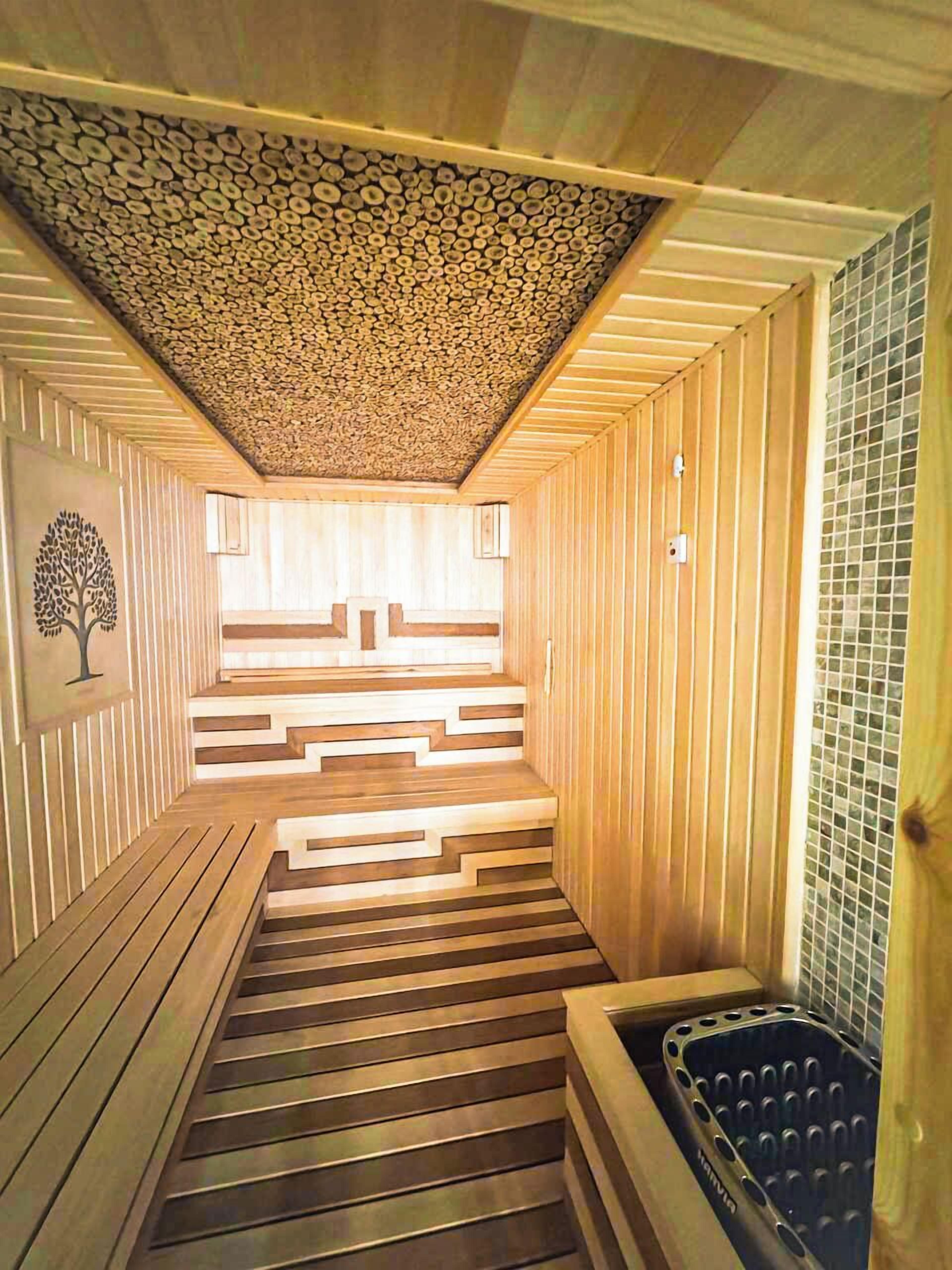 Un sauna avec des bancs en bois et un mur recouvert de carreaux.