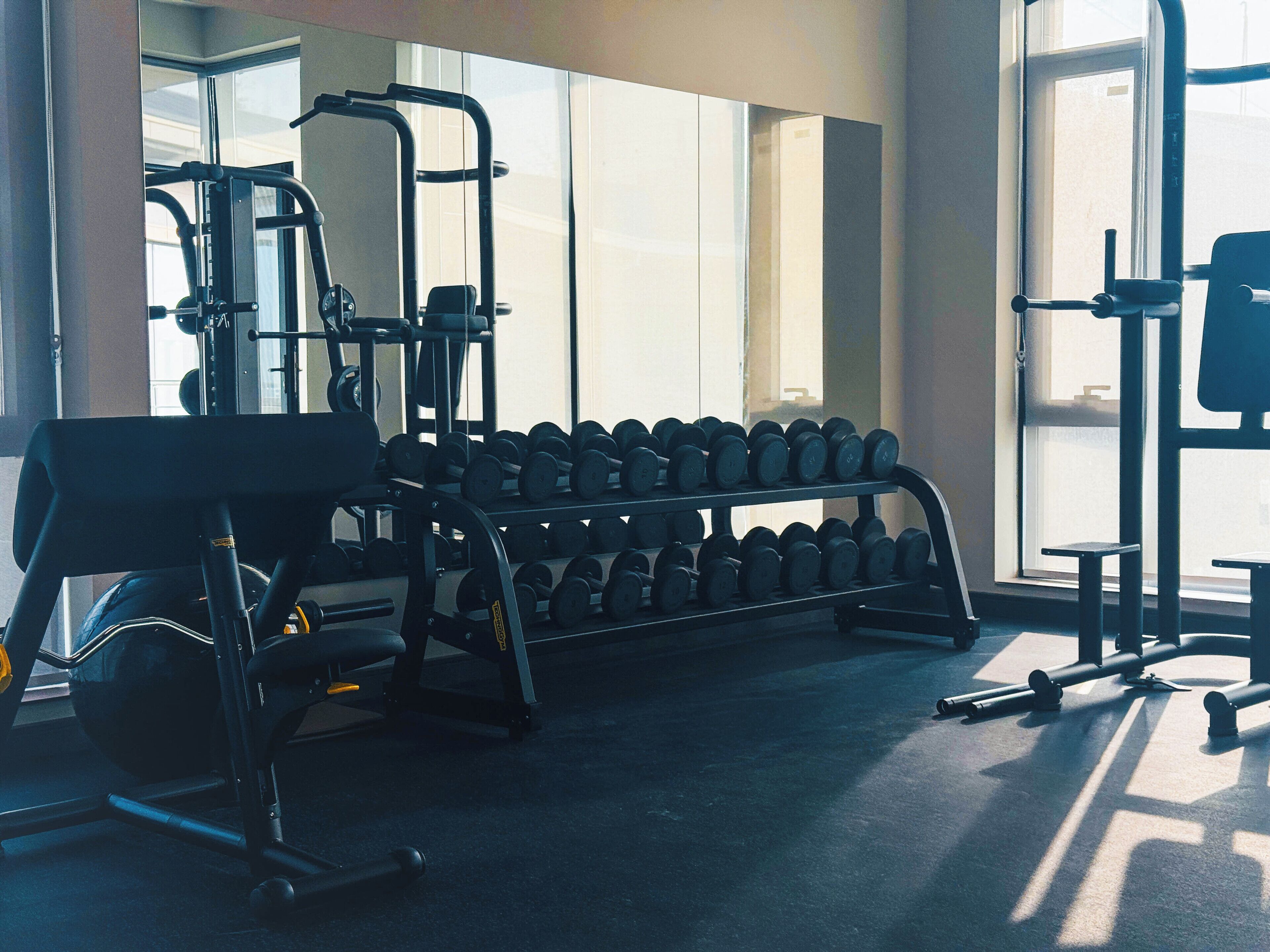 Ein Fitnessraum mit Trainingsgeräten und Hanteln.