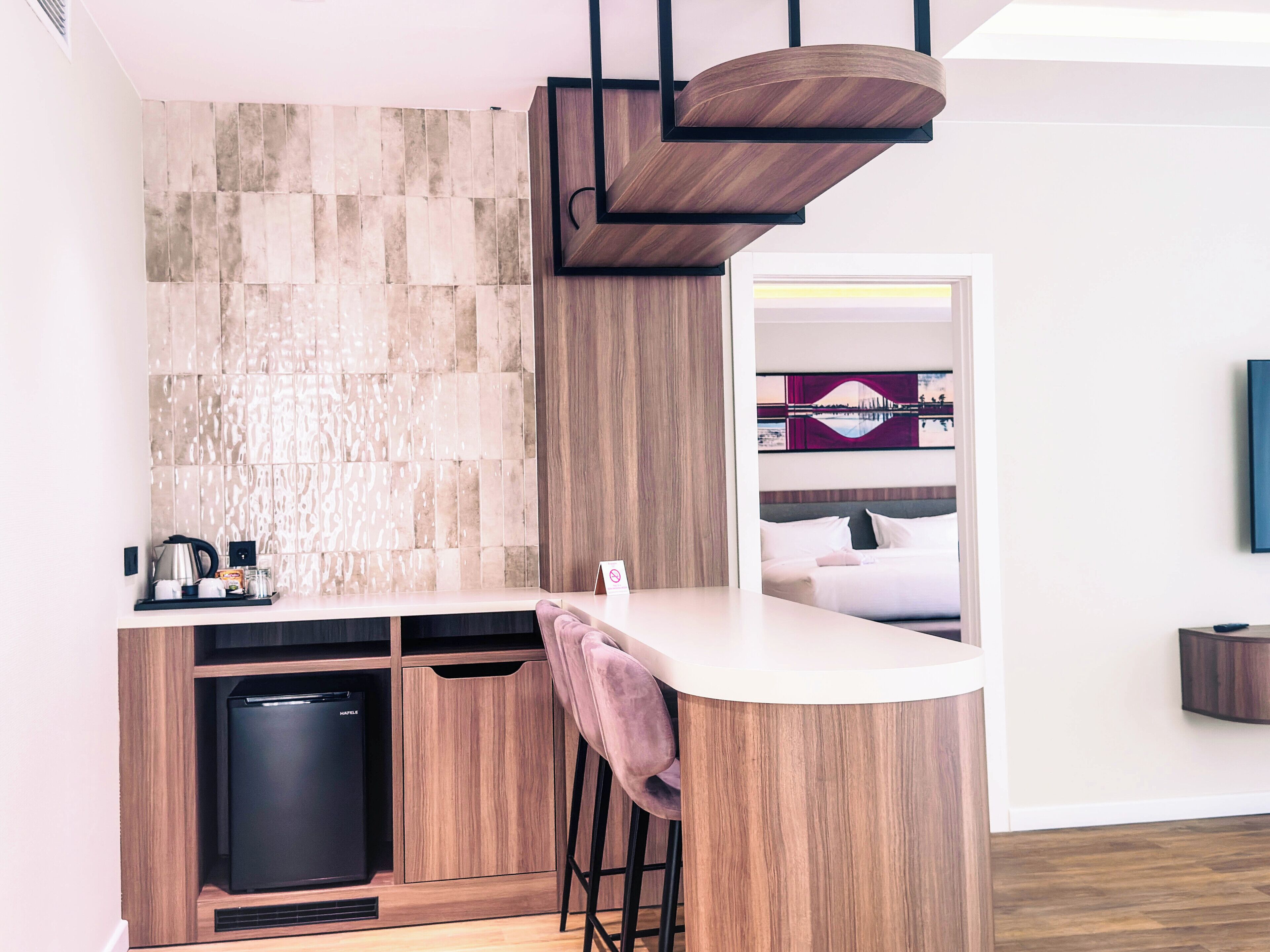 Una cocina moderna con refrigerador integrado, armarios de madera y una zona de bar con taburetes.