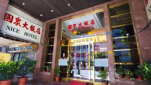 The exterior of NICE HOTEL with clear signage, a checkered floor, and potted plants at the entrance. - Nice Hotel (Kaohsiung)