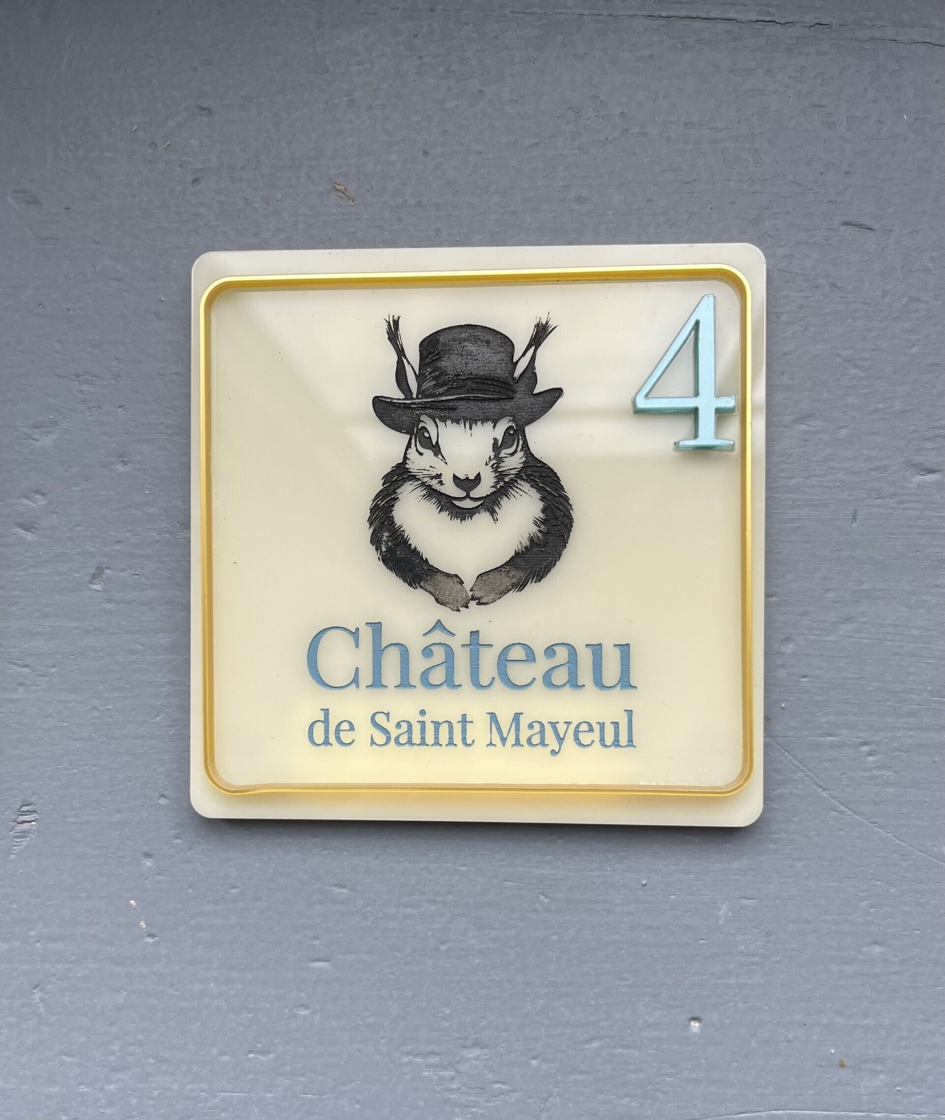 Une pancarte représentant un lapin portant un chapeau, avec le texte « Château de Saint-Mayeux » et le chiffre « 4 ».
