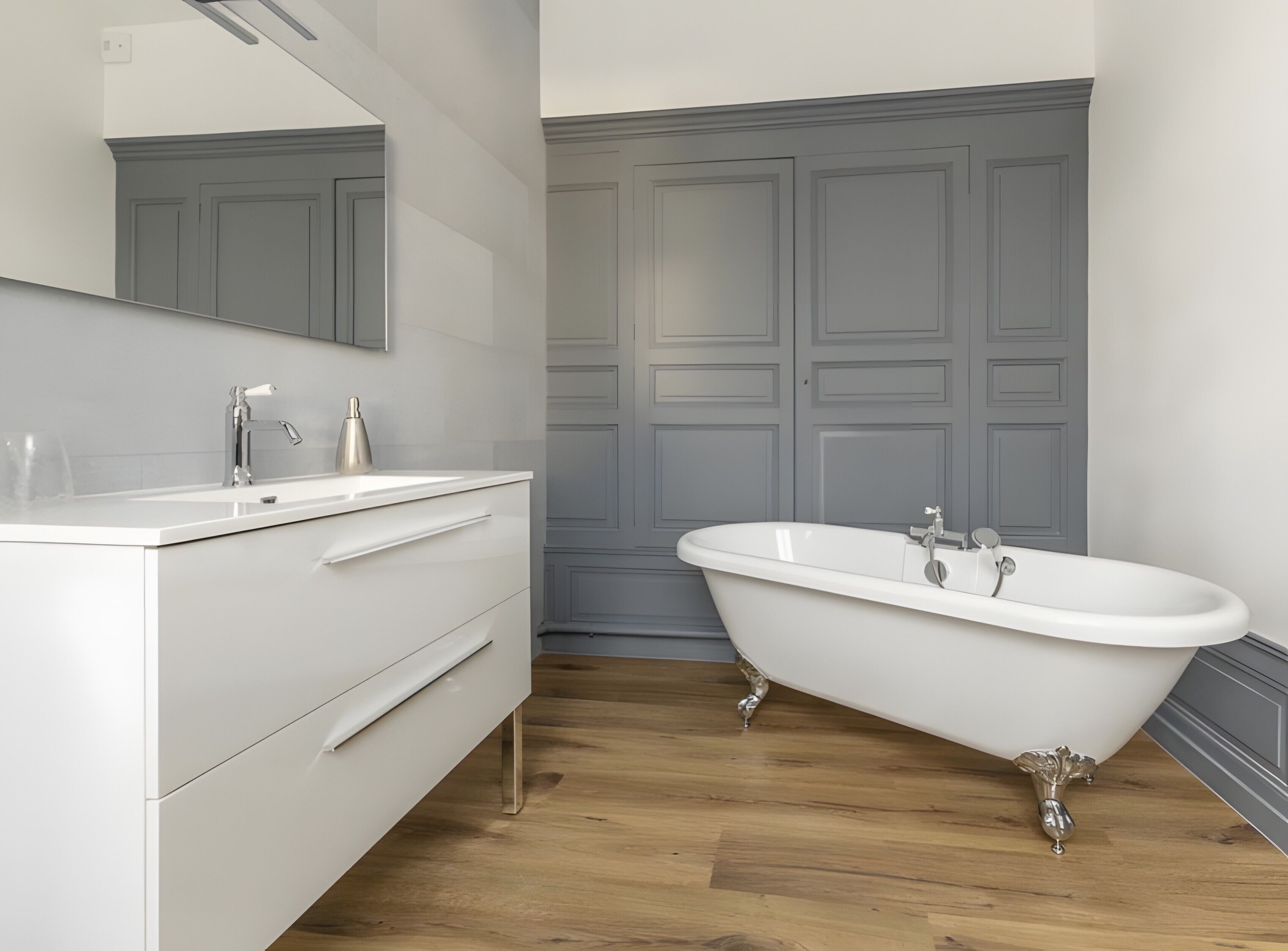 A bathroom with a white vanity, a freestanding bathtub, and a large mirror.