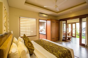 Une chambre à coucher avec un lit, une armoire et une salle de bain visible à travers une porte.