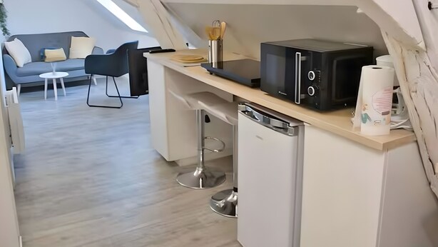 Une petite cuisine équipée d’un four à micro-ondes, d’un petit réfrigérateur et d’une machine à café.