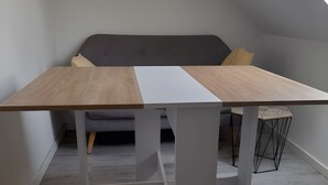 Une chambre de style loft moderne, avec un lit en mezzanine, un bureau blanc et une vue sur le ciel.