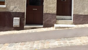 A building with two doors, a window, and a number sign.