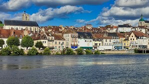 A riverside town with historic buildings, a prominent church, and a bridge.